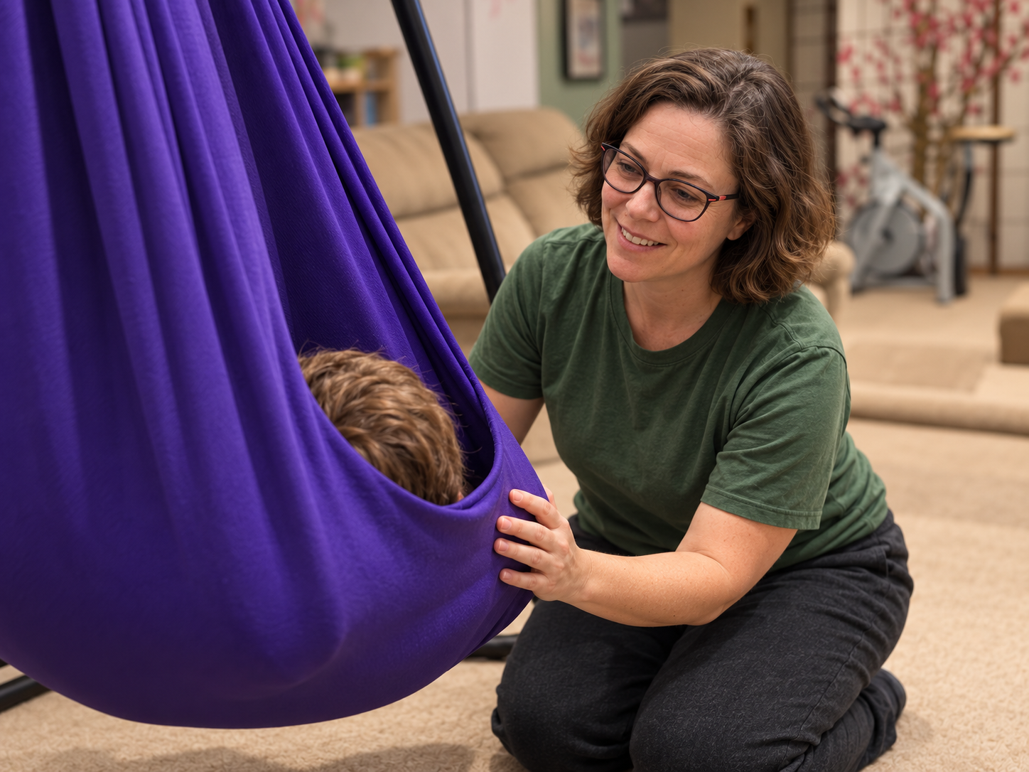 Therapist supporting a child in a sensory swing